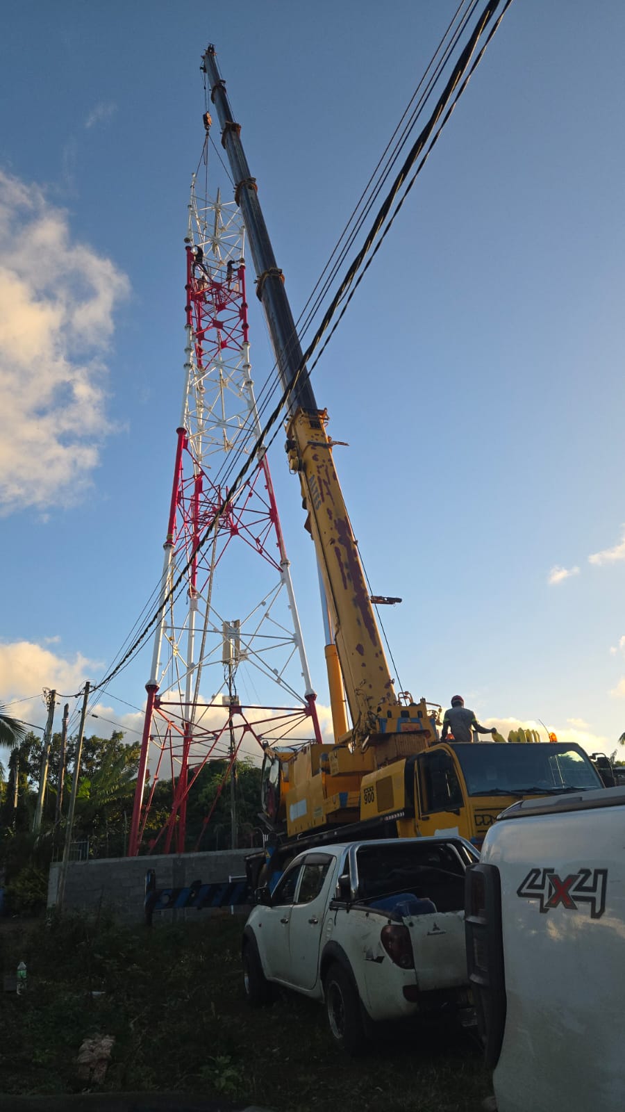 JSTL crane at a red and white telecom tower