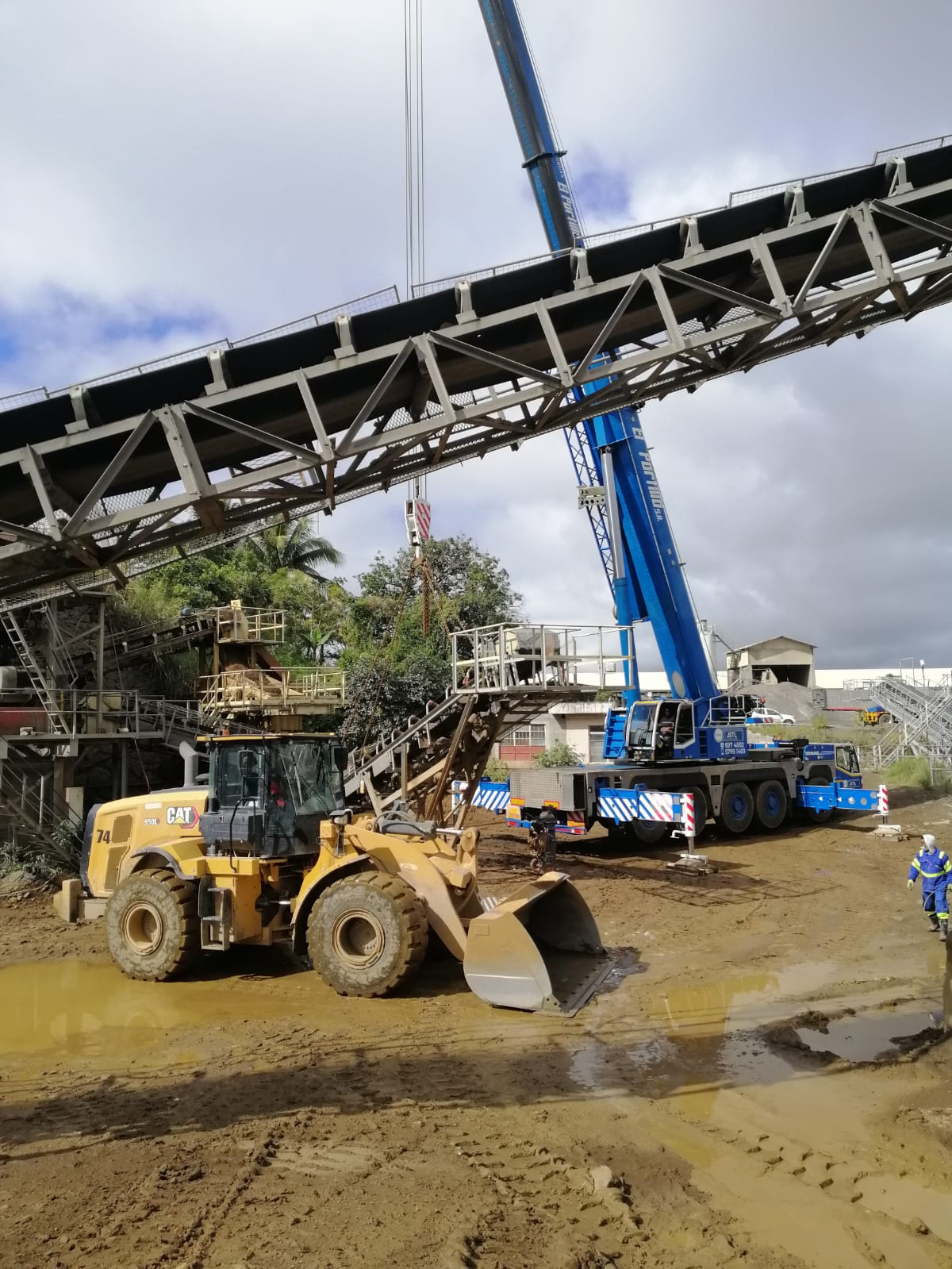 JSTL crane at an industrial conveyor with a CAT loader