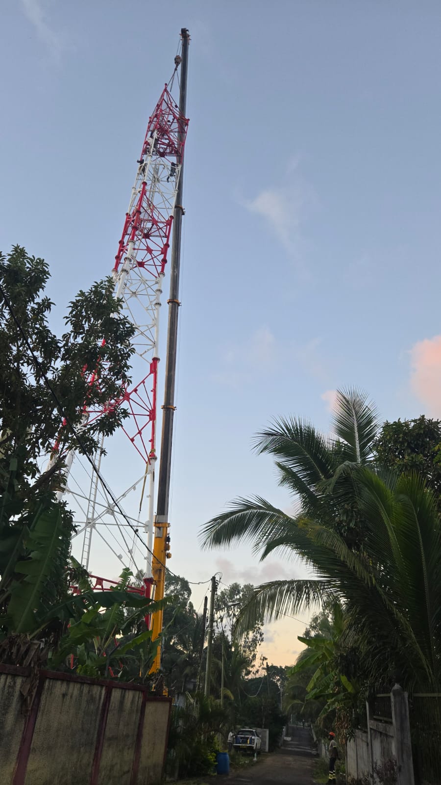 Crane boom raised at a telecom mast