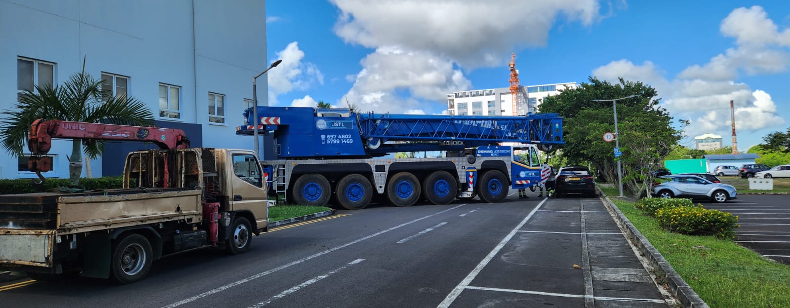 Blue JSTL Demag crane arriving at a site